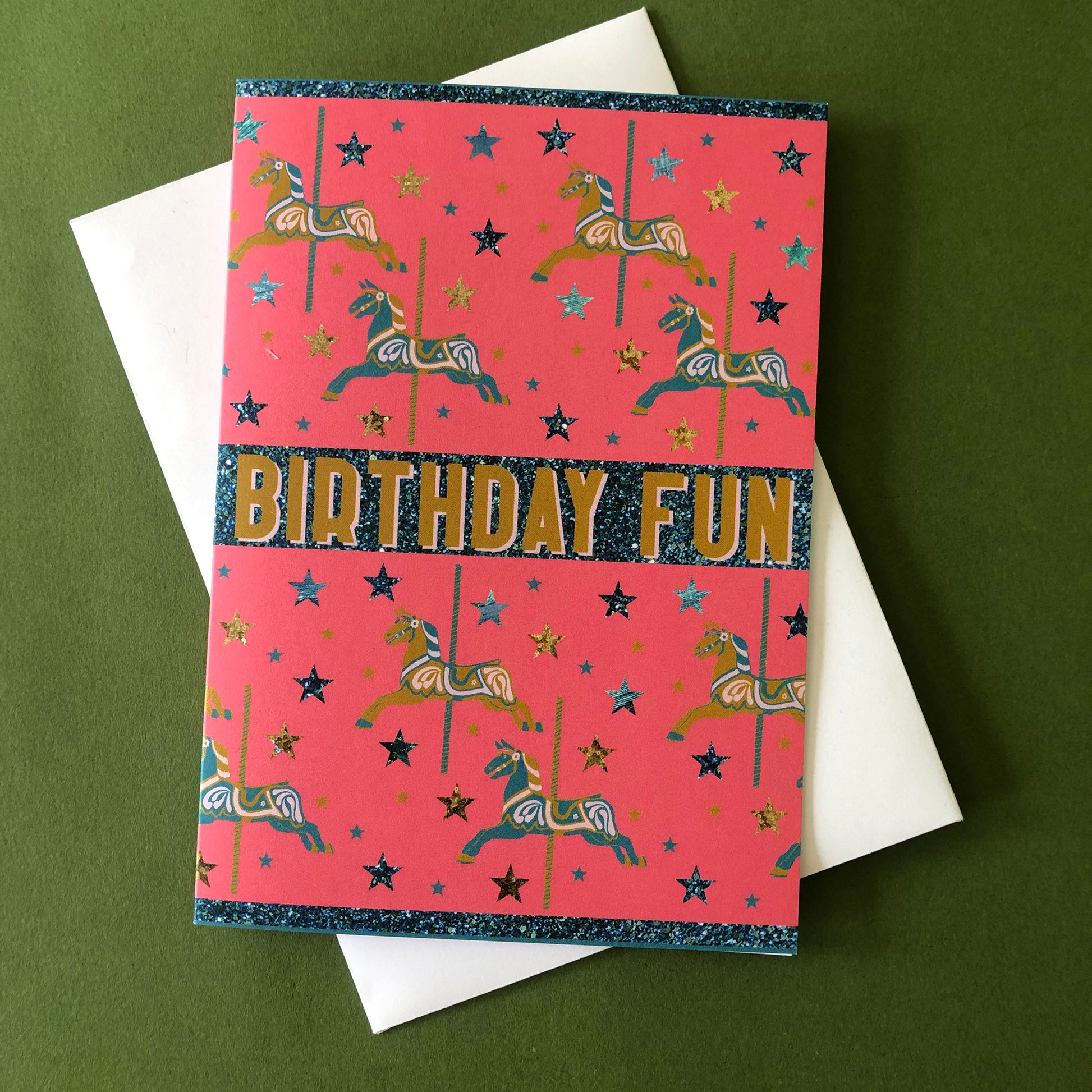 Bright and fun birthday card featuring a carousel horse design on a background of confetti