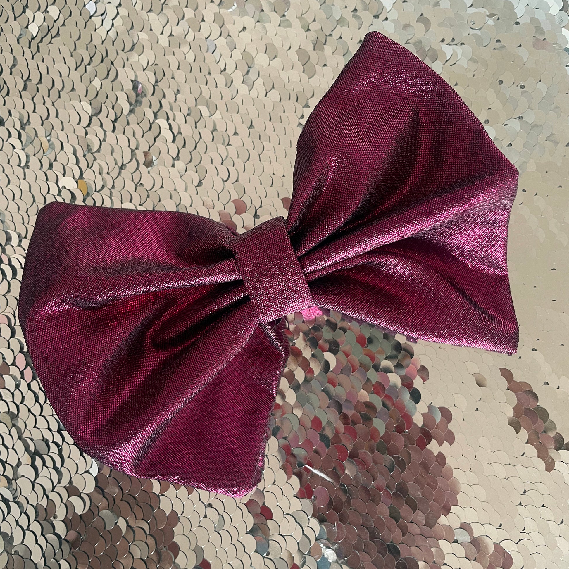 Image shows a pink, metallic hair bow made from high quality lamé fabric.