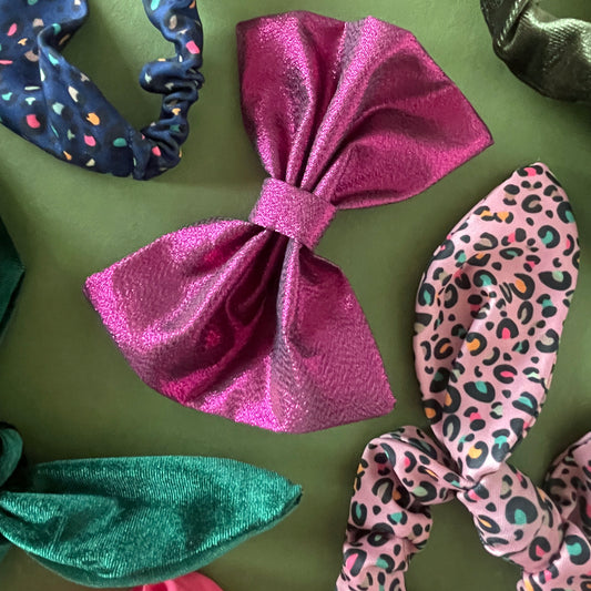 Image shows a pink, metallic hair bow made from high quality lamé fabric.