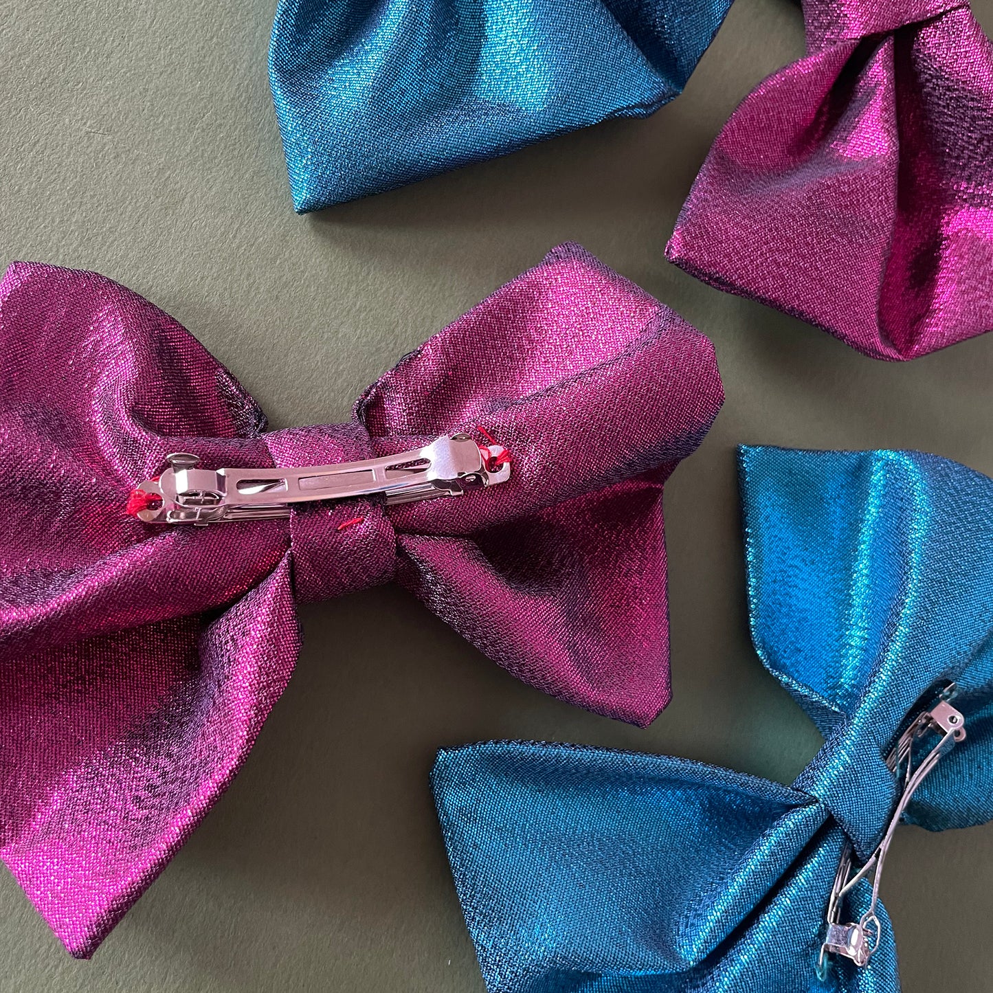 Image shows a pink, metallic hair bow made from high quality lamé fabric.