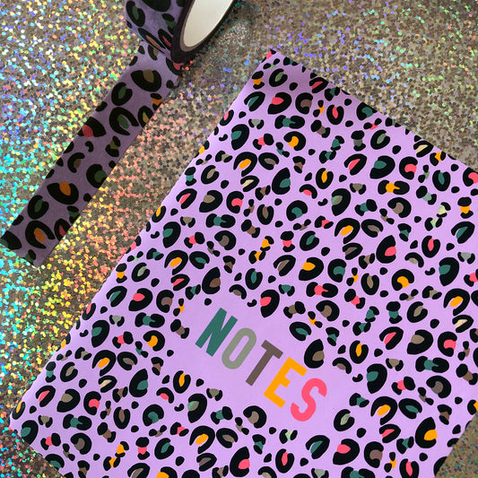 Image shows an A6 notebook in a bright purple with a leopard print pattern featuring pops of neon