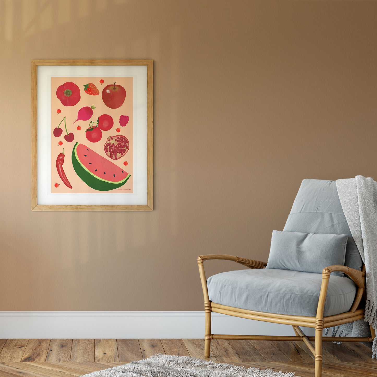 Image of a framed art print of red fruit and vegetables on a peach background.