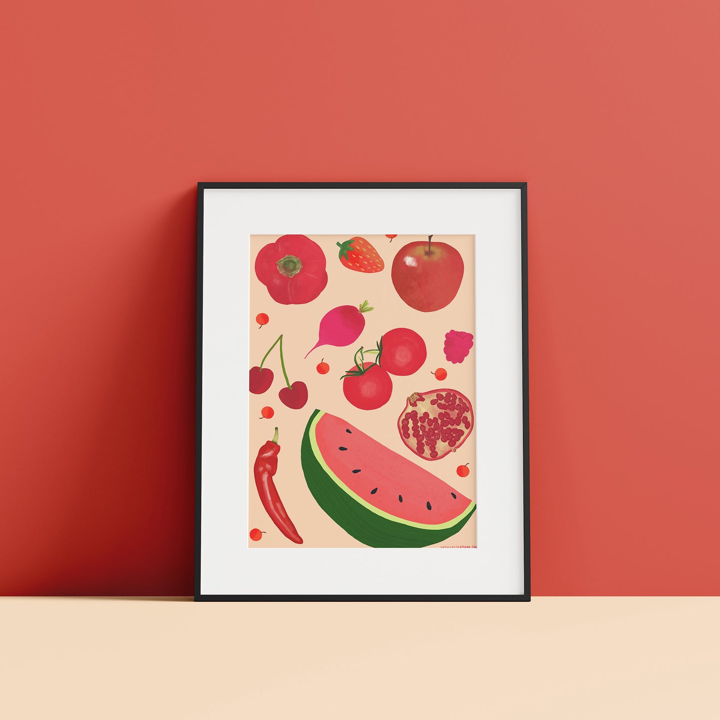 Image of a framed art print of red fruit and vegetables on a peach background.