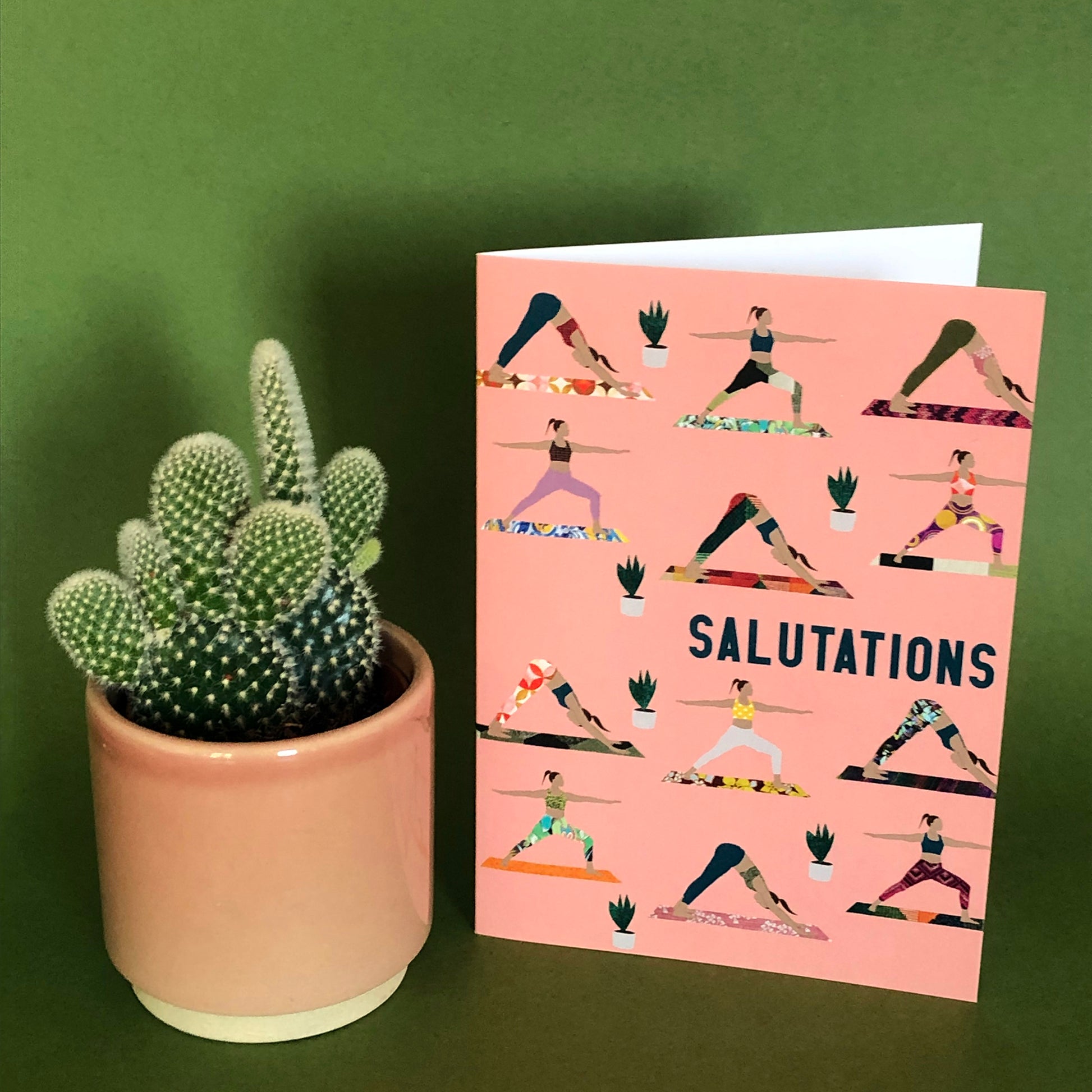 Image shows an everyday greetings card that says 'salutations' and features a fun pattern of women doing yoga poses on colourful yoga mats