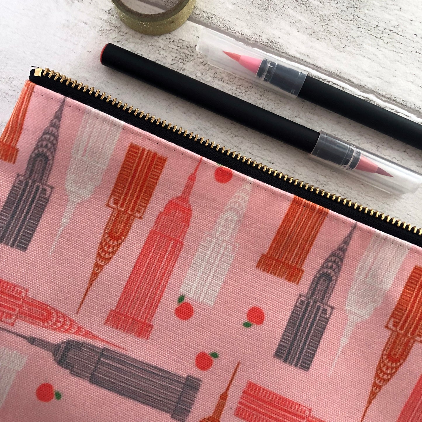 Handy zip pouch in pastel pink featuring a unique design inspired by the skyscrapers of NYC 