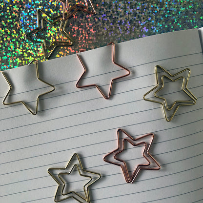 Image shows a set of gold and rose gold, starshaped paperclips.