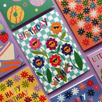 Colorful birthday cards with floral designs and text on a purple background