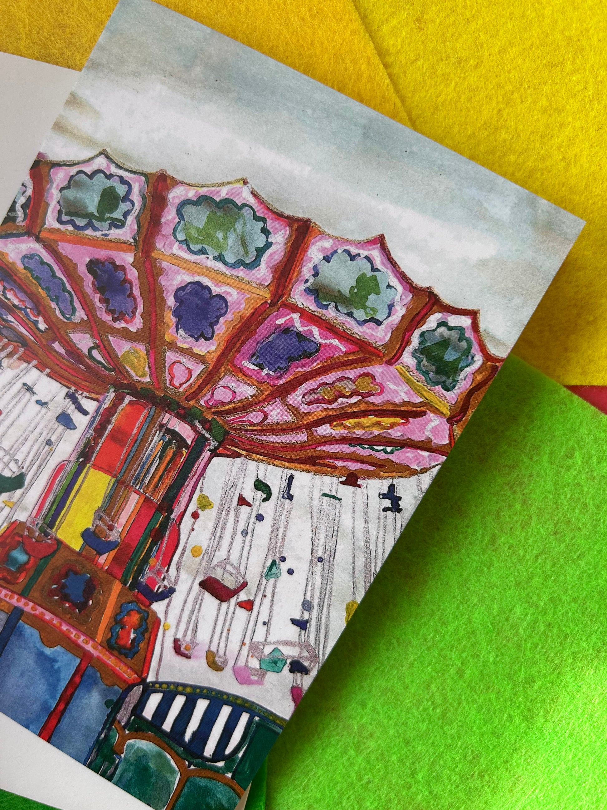 Greeting card with a colourful carousel design on a green and yellow background