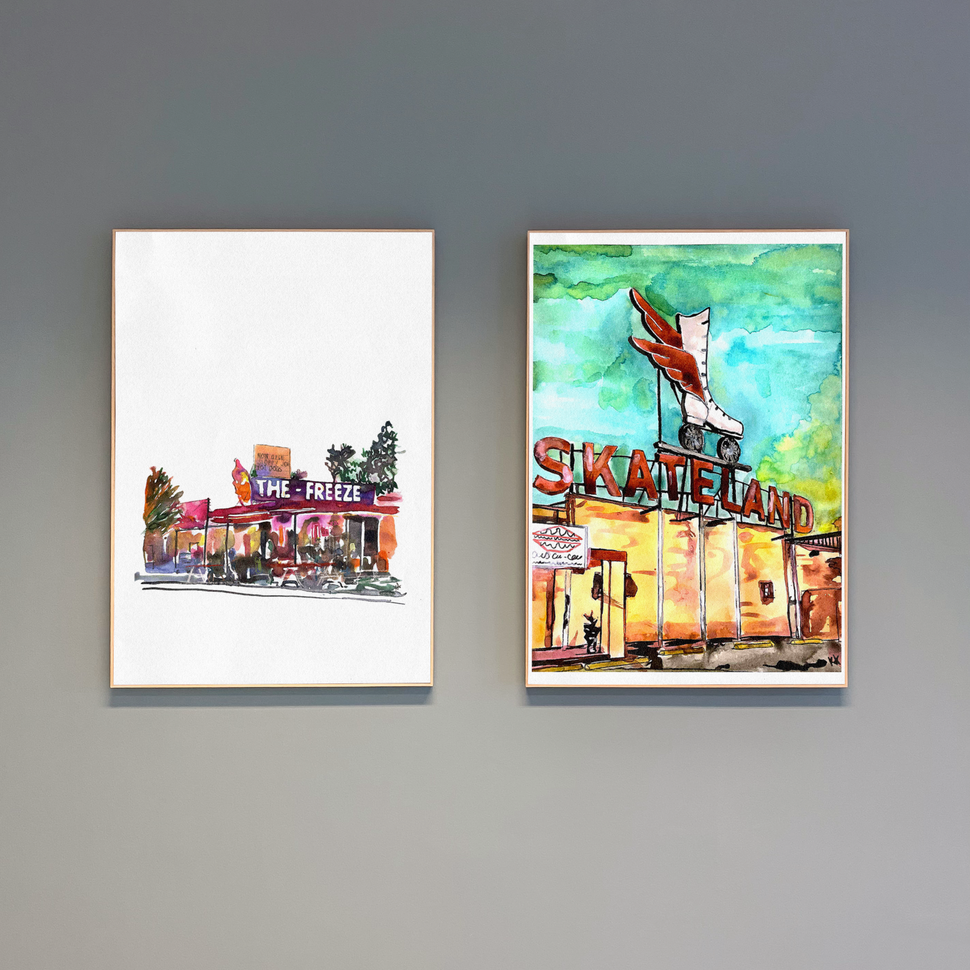 Two framed artworks on a gray wall, one titled 'The Freeze' and the other 'Skateland'.