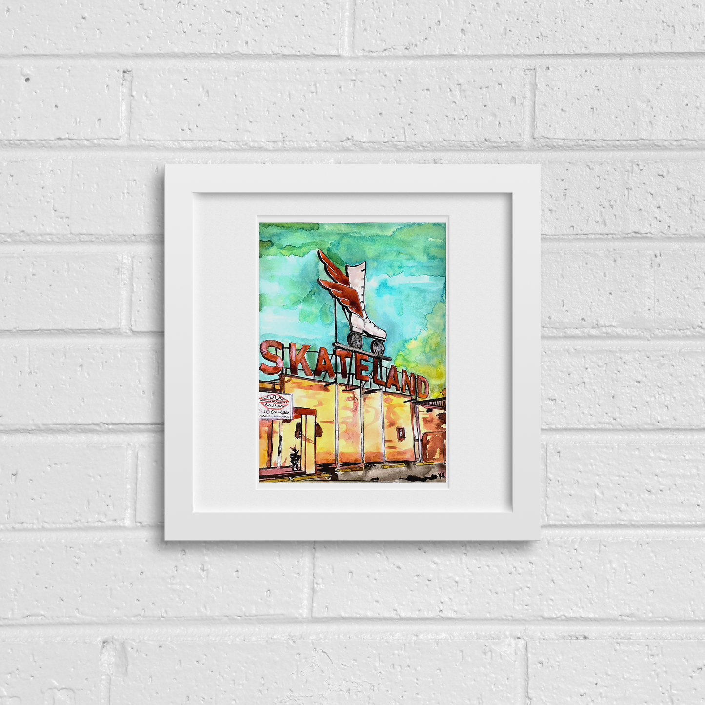 Framed artwork of a skateland scene on a white brick wall