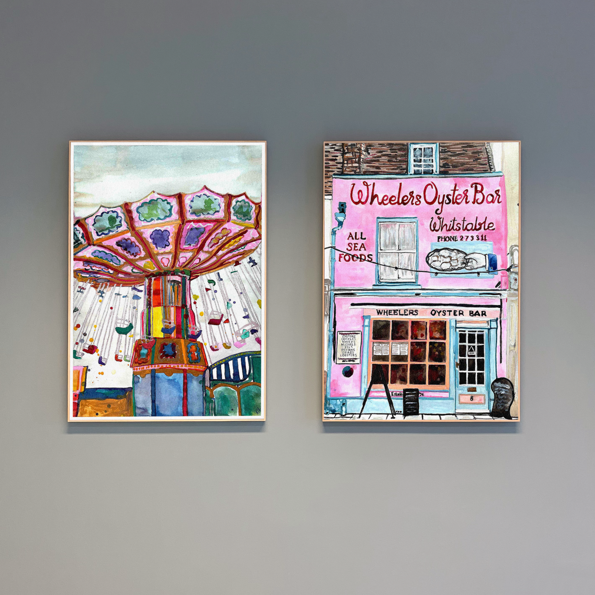 Two framed artworks on a grey wall, one depicting a colourful carousel and the other an oyster bar.