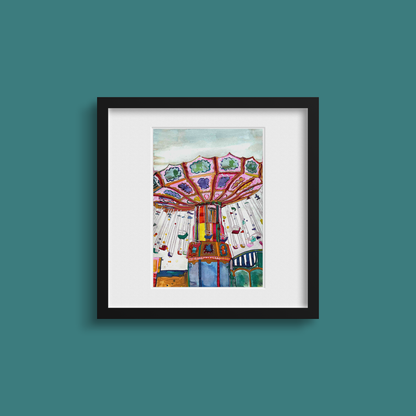 Framed artwork of a colourful carousel on a teal wall