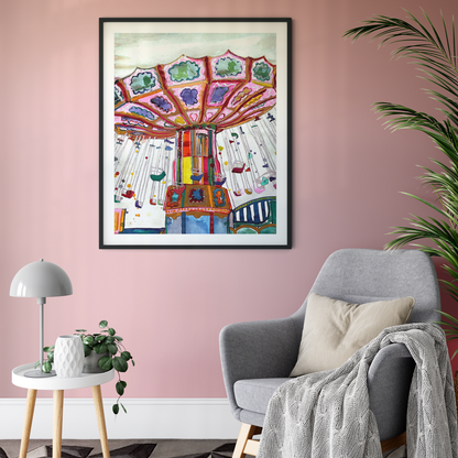 Colourful framed artwork on a pink wall above a grey armchair with a plant and small table.