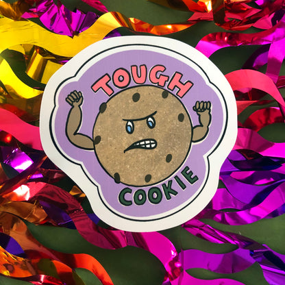 Image shows a vinyl sticker featuring an illustration of a cookie with muscles and the wording 'Tough Cookie'