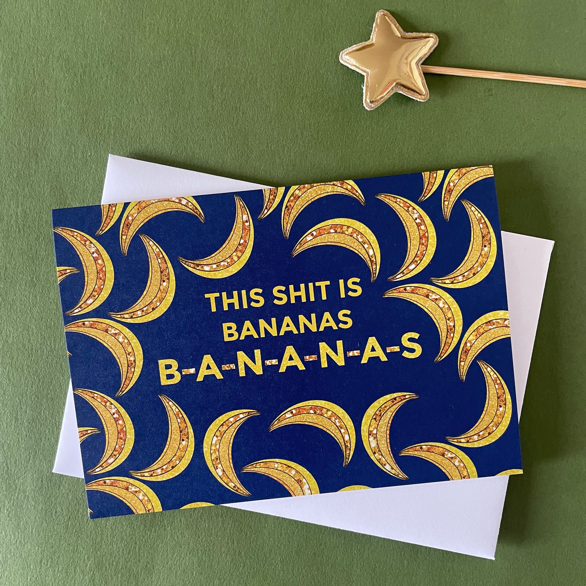 Image of a blue card on a green background. The card features bejewelled illustrations of bananas and the message 'This Shit is Bananas B-A-N-A-N-A-S.