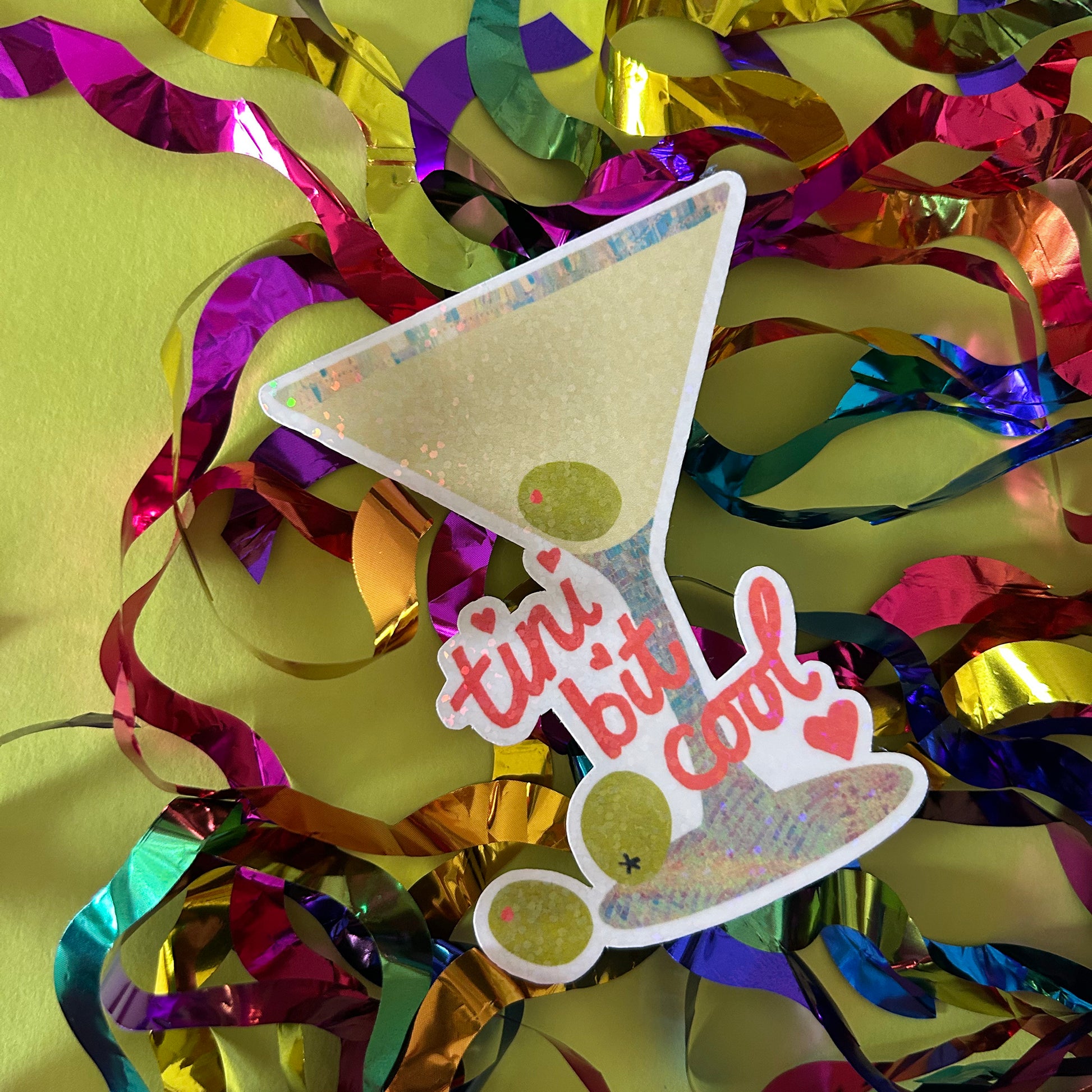 Colorful confetti with a 'tini bit cool' cocktail-themed decoration on a yellow background
