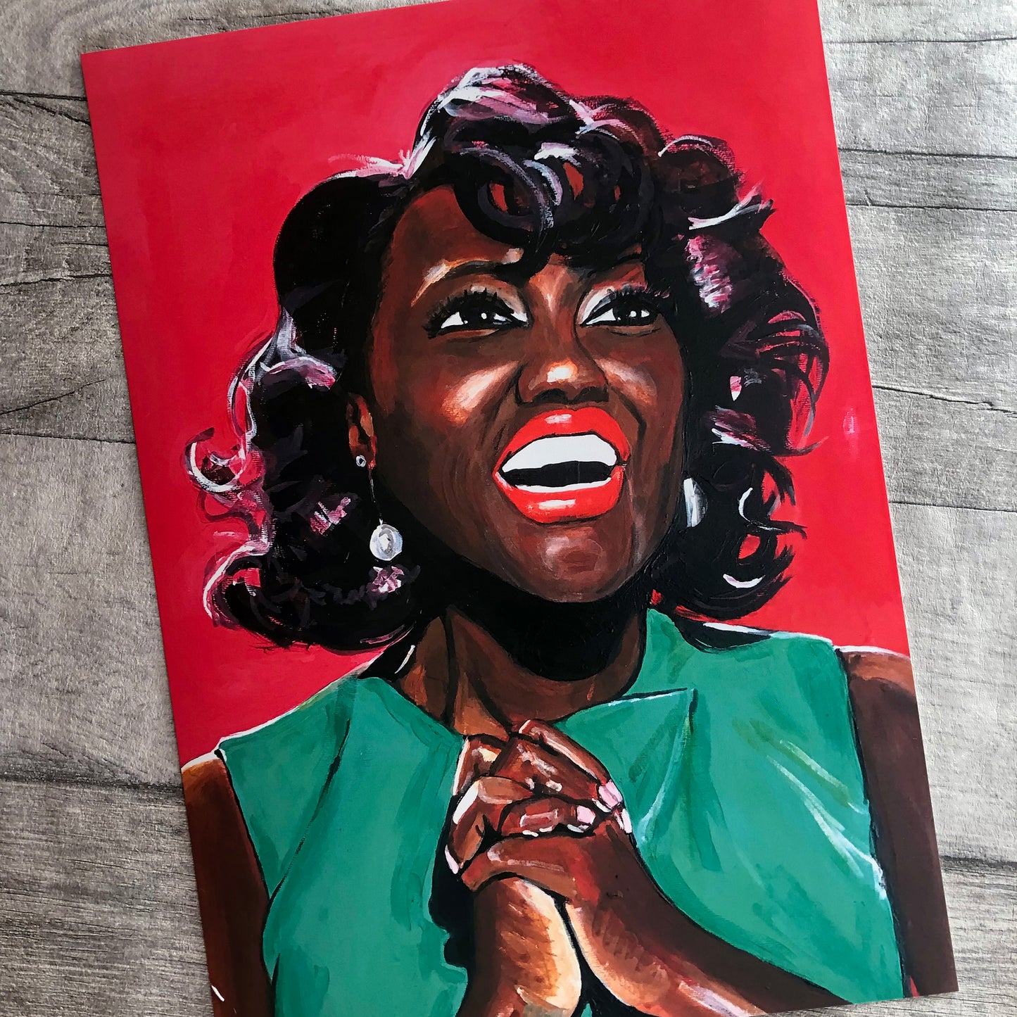 Image shows a joyful portrait of Viola Davis wearing a bright green dress, clasping her hands together and smiling on a bright pink background