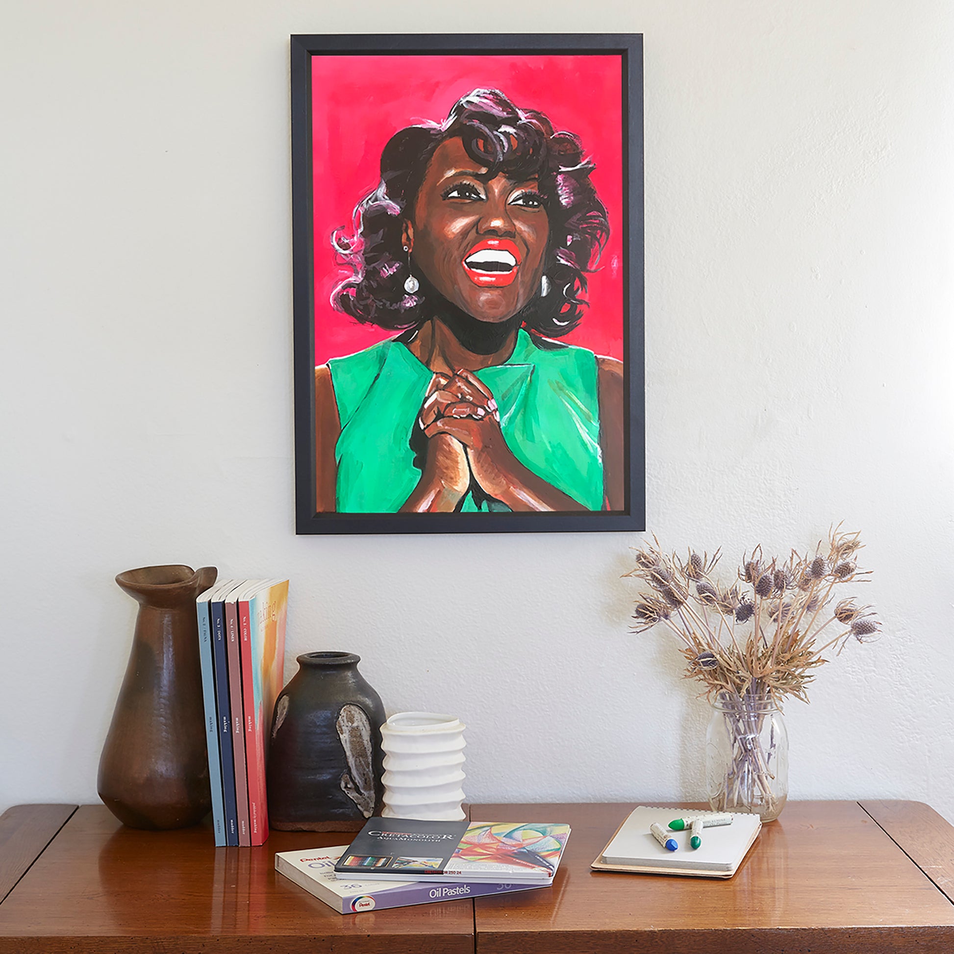 Image shows a joyful portrait of Viola Davis wearing a bright green dress, clasping her hands together and smiling on a bright pink background