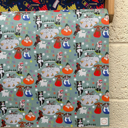 A festive Christmas gift wrap featuring a repeating pattern of dogs doing winter sports on a muted blue green background.
